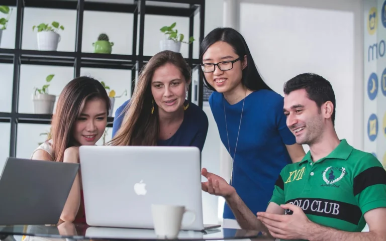 Team reviewing work together on a laptop